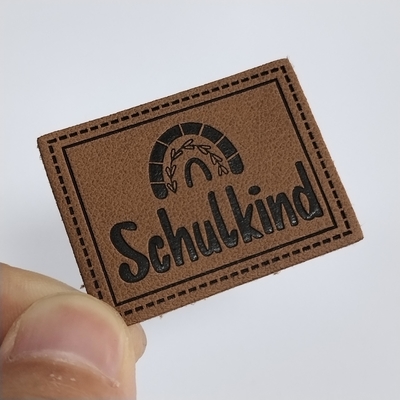 Microfiber Embossed Logo PU Leather Label Menjahit Pakaian Sesuaikan Desain